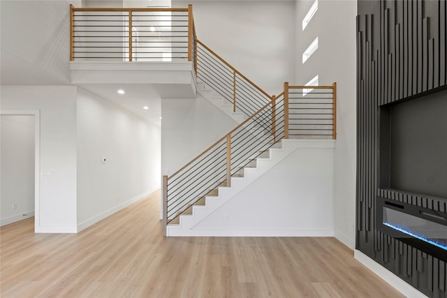 foyer featuring a towering ceiling and light wood-type flooring