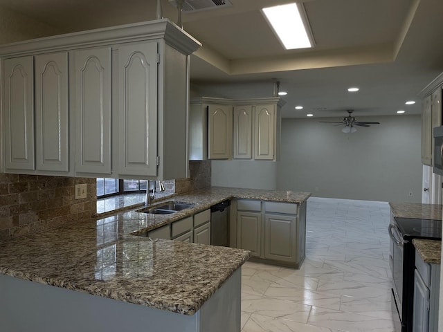 kitchen with stainless steel appliances, kitchen peninsula, sink, and a raised ceiling