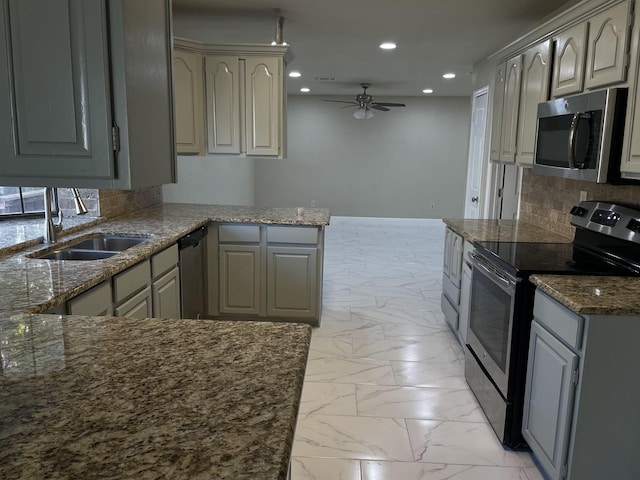 kitchen with sink, ceiling fan, appliances with stainless steel finishes, gray cabinetry, and decorative backsplash