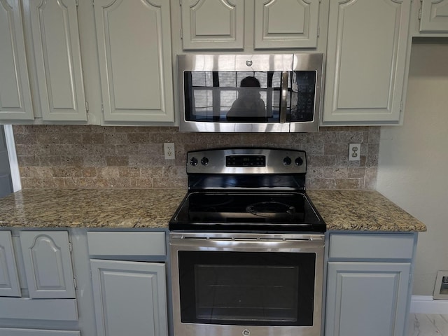 kitchen featuring tasteful backsplash, appliances with stainless steel finishes, stone countertops, and white cabinets