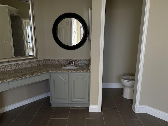 bathroom with tile patterned flooring, vanity, and toilet