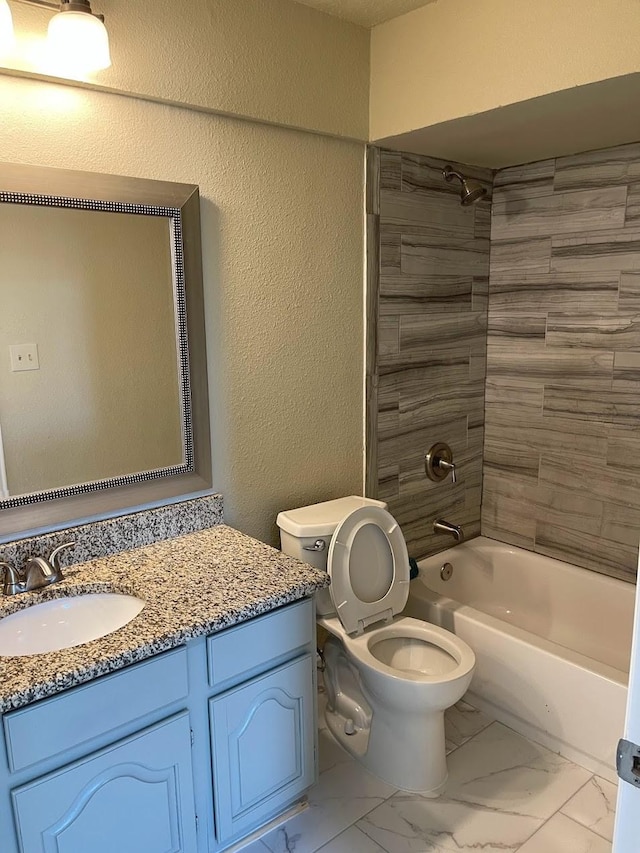 full bathroom featuring vanity, tiled shower / bath combo, and toilet