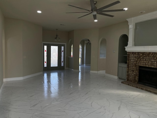 unfurnished living room with ceiling fan and a fireplace