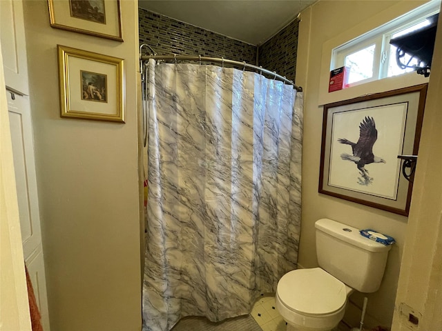 bathroom with toilet and a shower with shower curtain