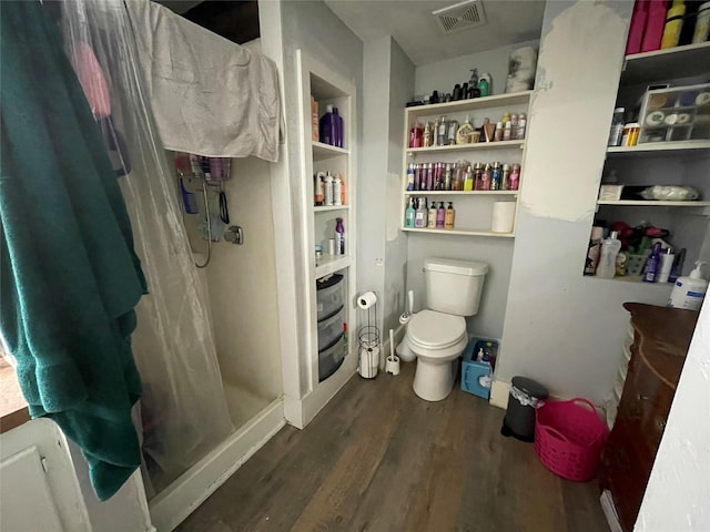 bathroom featuring wood-type flooring, toilet, and walk in shower