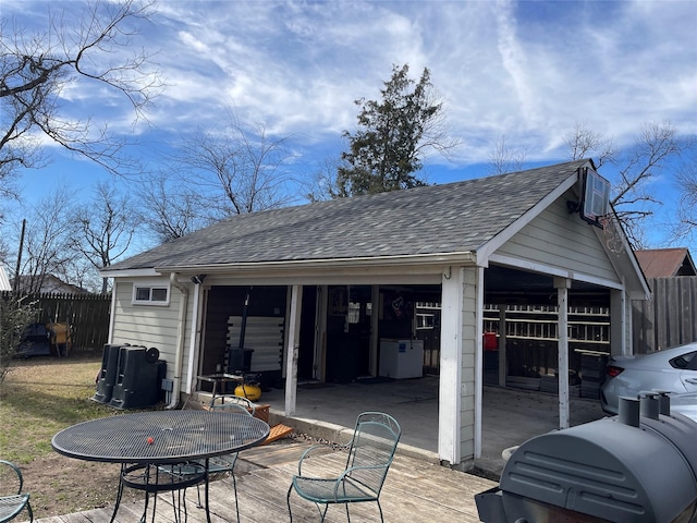 exterior space featuring a garage, a wooden deck, an outdoor structure, and grilling area