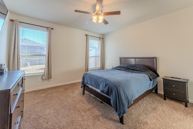 bedroom with multiple windows, light colored carpet, and ceiling fan