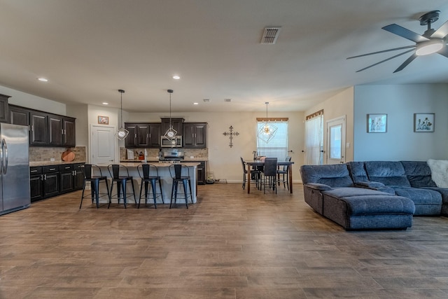 living room featuring dark wood-type flooring and ceiling fan