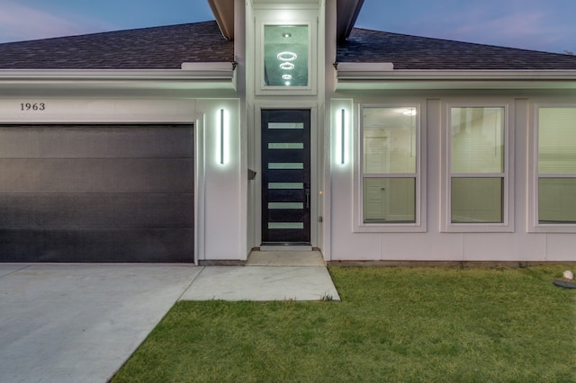 exterior entry at dusk featuring a yard