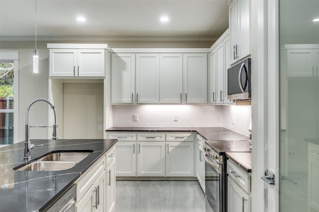 kitchen featuring sink, decorative light fixtures, white cabinets, and appliances with stainless steel finishes