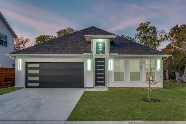 view of front of property with a garage and a lawn