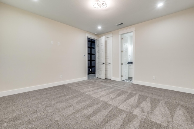 unfurnished bedroom with connected bathroom and carpet floors