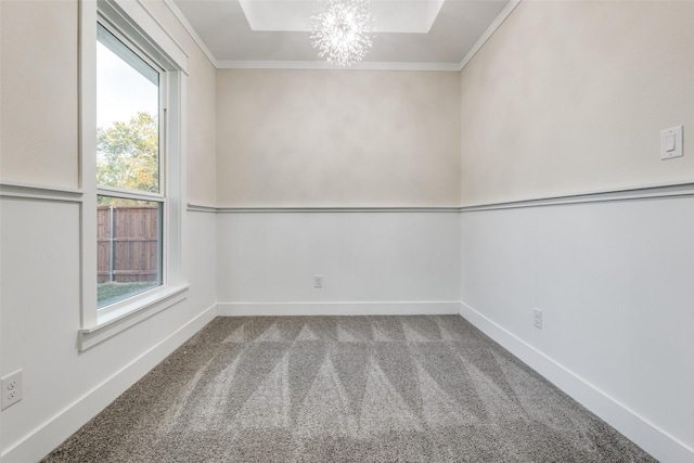 empty room featuring ornamental molding, carpet flooring, and an inviting chandelier