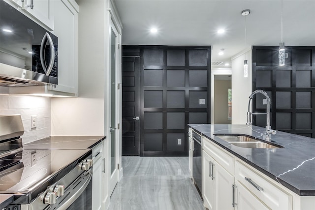 kitchen featuring sink, appliances with stainless steel finishes, white cabinetry, backsplash, and decorative light fixtures