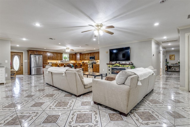 living room with a wealth of natural light, ornamental molding, and ceiling fan