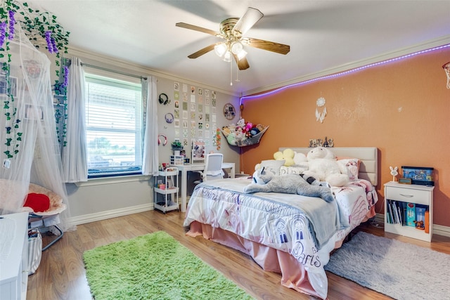 bedroom featuring hardwood / wood-style flooring, crown molding, and ceiling fan