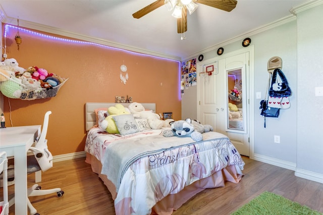 bedroom featuring hardwood / wood-style flooring, ornamental molding, and ceiling fan