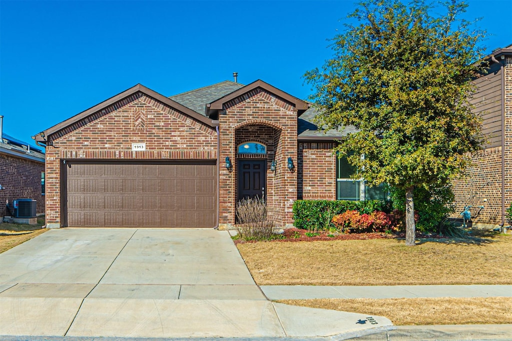 view of front of home featuring cooling unit and a garage