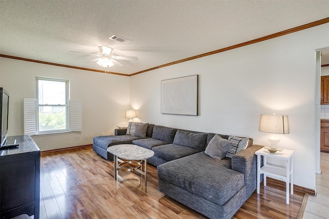 living area featuring ceiling fan, visible vents, light wood-style floors, and ornamental molding