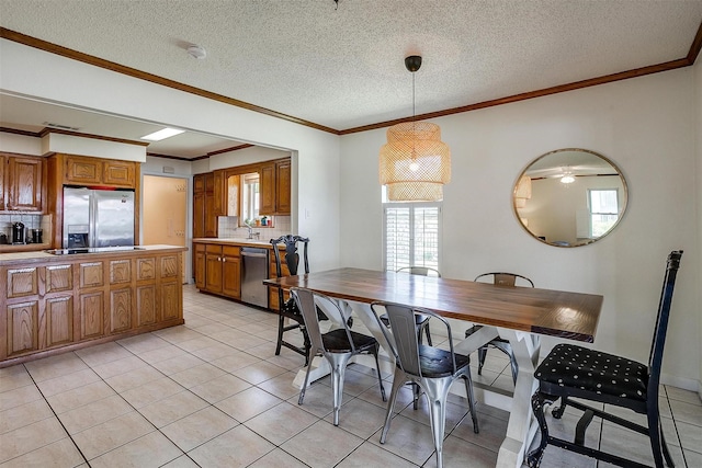 dining area with ornamental molding, a textured ceiling, and light tile patterned floors