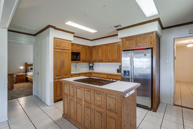 kitchen featuring light tile patterned floors, tile counters, visible vents, and black appliances