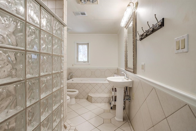 full bath featuring a garden tub, crown molding, tile patterned floors, toilet, and visible vents