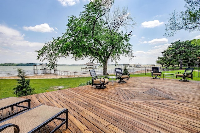 wooden deck featuring fence, a yard, and a water view