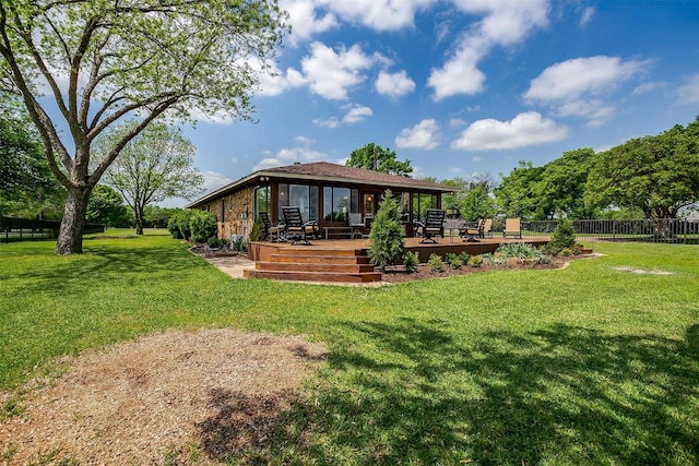 rear view of property with fence, a yard, and a deck