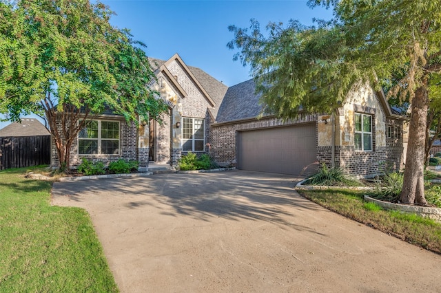 view of front of home with concrete driveway, an attached garage, fence, and brick siding