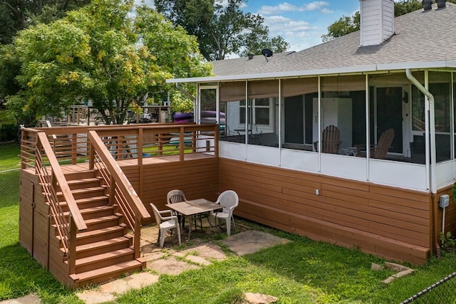 rear view of house with a deck and a sunroom