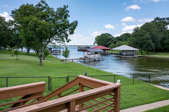 dock area with a water view and a yard