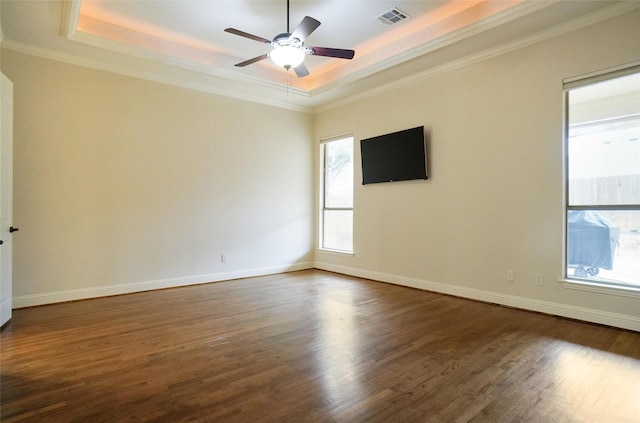 unfurnished room featuring dark hardwood / wood-style floors, ceiling fan, a tray ceiling, and crown molding