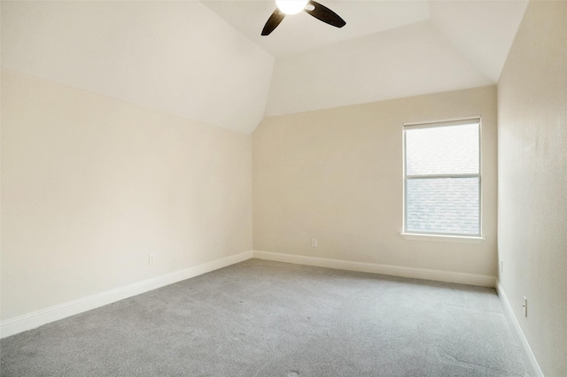 carpeted spare room featuring ceiling fan and vaulted ceiling