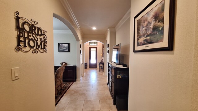 corridor featuring ornamental molding and light tile patterned floors