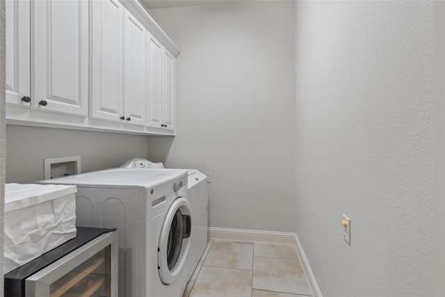 clothes washing area featuring independent washer and dryer, light tile patterned floors, beverage cooler, and cabinets