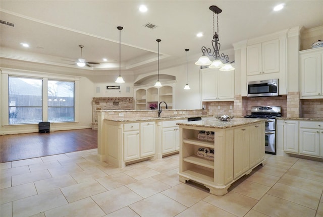 kitchen with a kitchen island, appliances with stainless steel finishes, pendant lighting, sink, and kitchen peninsula