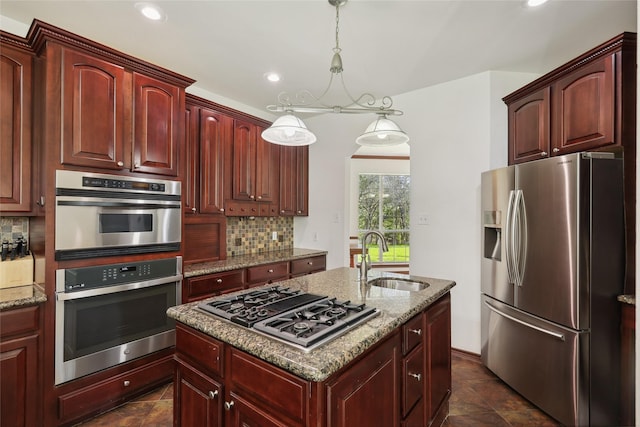 kitchen featuring decorative light fixtures, tasteful backsplash, sink, light stone counters, and stainless steel appliances