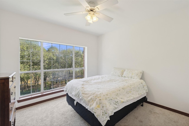 carpeted bedroom featuring multiple windows and ceiling fan