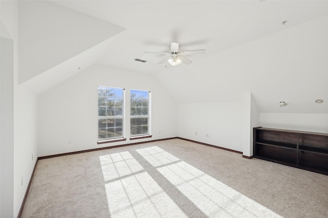 additional living space featuring vaulted ceiling, light colored carpet, and ceiling fan