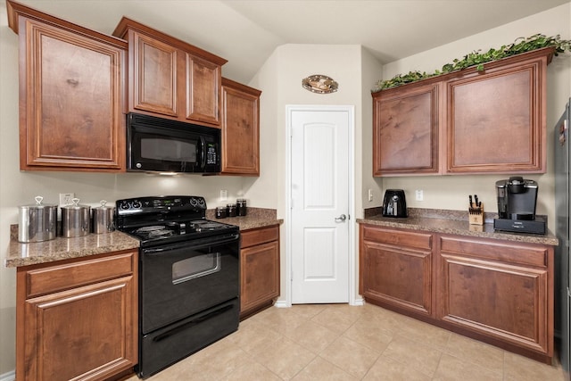 kitchen featuring vaulted ceiling, black appliances, and light tile patterned flooring