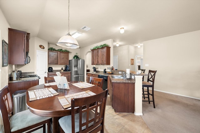 carpeted dining room featuring lofted ceiling and sink