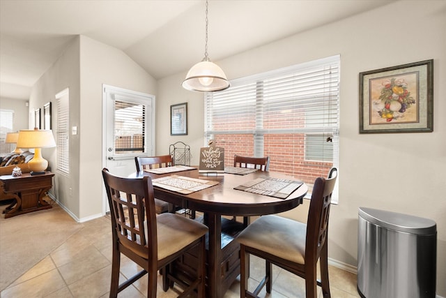 dining area featuring light tile patterned flooring, lofted ceiling, and plenty of natural light