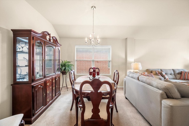 dining room with an inviting chandelier, light colored carpet, and lofted ceiling