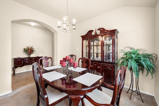 dining space with lofted ceiling, light carpet, and a chandelier