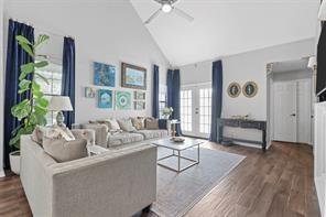 living room with high vaulted ceiling, dark hardwood / wood-style floors, ceiling fan, and french doors