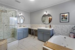 bathroom featuring vanity, ornamental molding, independent shower and bath, and tile walls