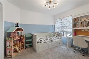 carpeted bedroom with a notable chandelier