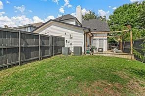 back of property with a yard and central air condition unit