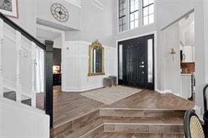 foyer entrance featuring a towering ceiling and hardwood / wood-style floors