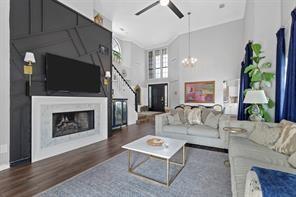 living room featuring high vaulted ceiling, ceiling fan with notable chandelier, and dark hardwood / wood-style flooring